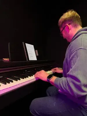 Student hraje na klavír ve zkušebně